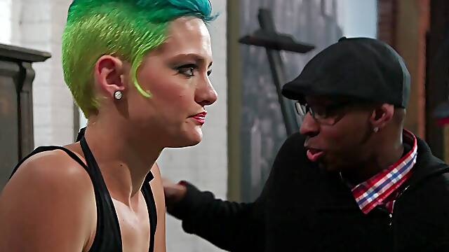 A crazy white girl with green hair rides a hung black guy